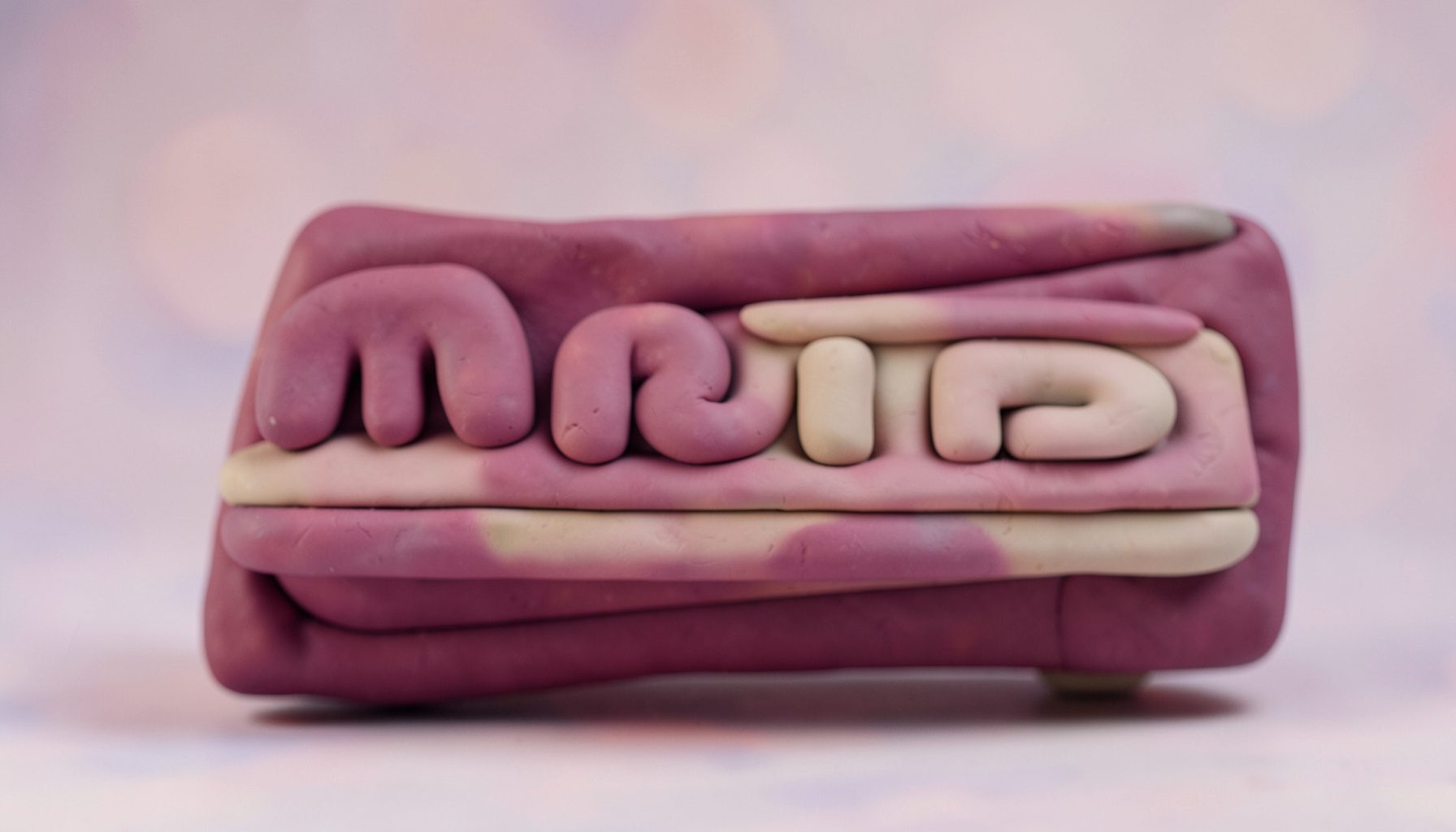 Soft clay-model cinema marquee with rounded letters, washed in rose and lavender bokeh